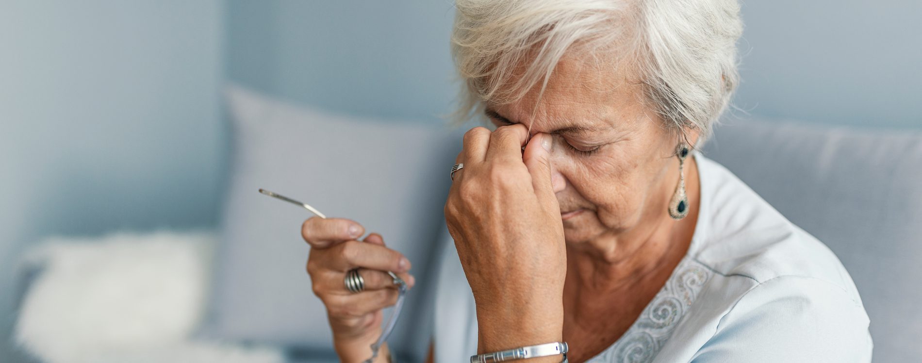 Older woman applying pressure onto sinus areas.