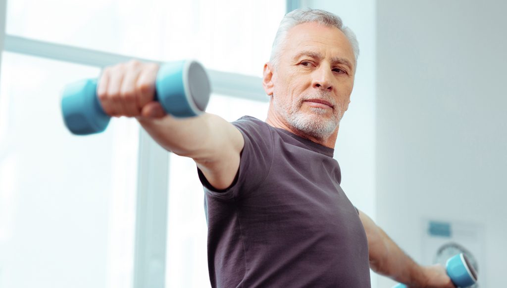 Older man with arms stretched out and light weights in his hands.