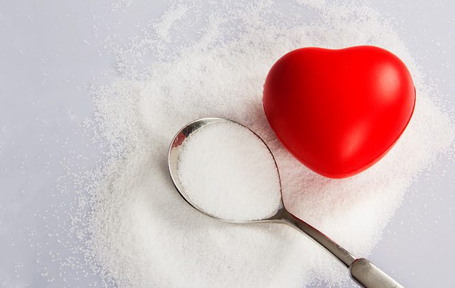 Spoon with salt on a pile of salt with heart shaped stress ball.