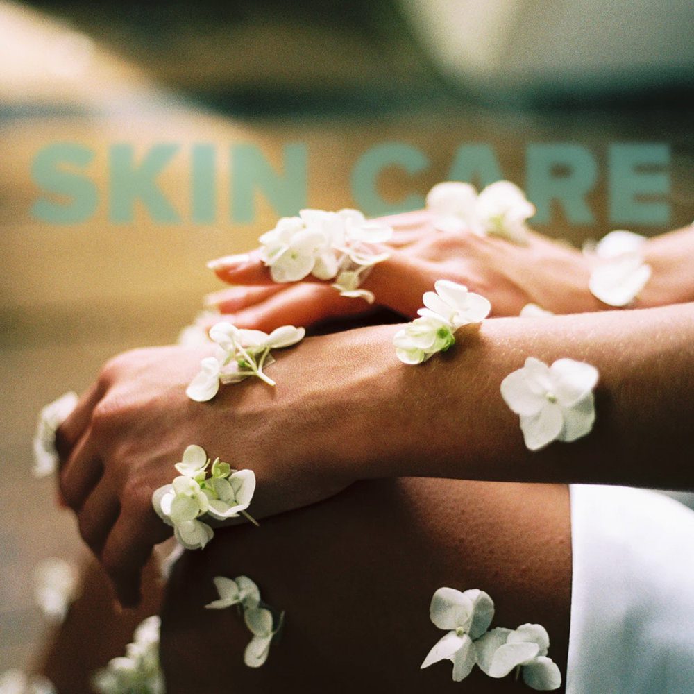 Flowers adorning a persons skin in representation of skin care.