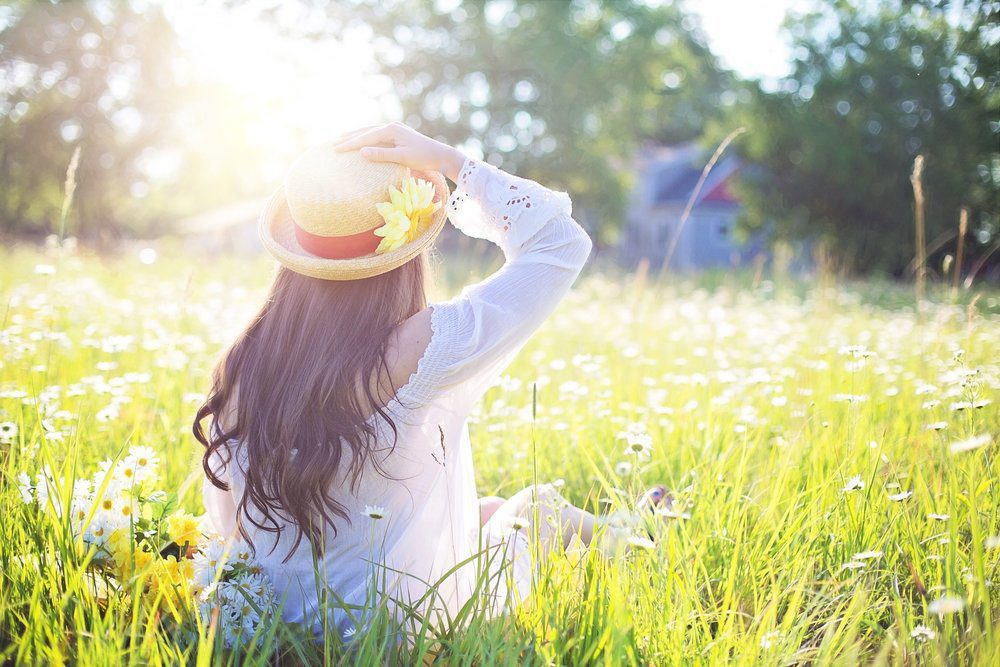 Woman sitting in an open field of wild flowers.