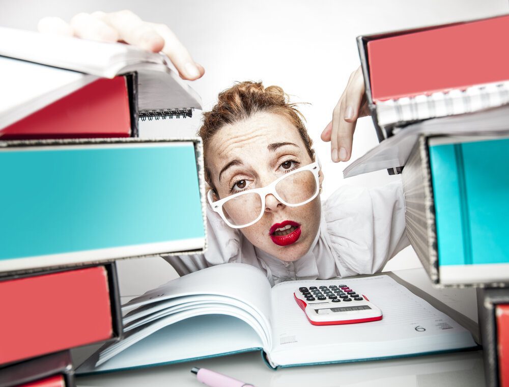Woman stress with and overload of work on her desk.