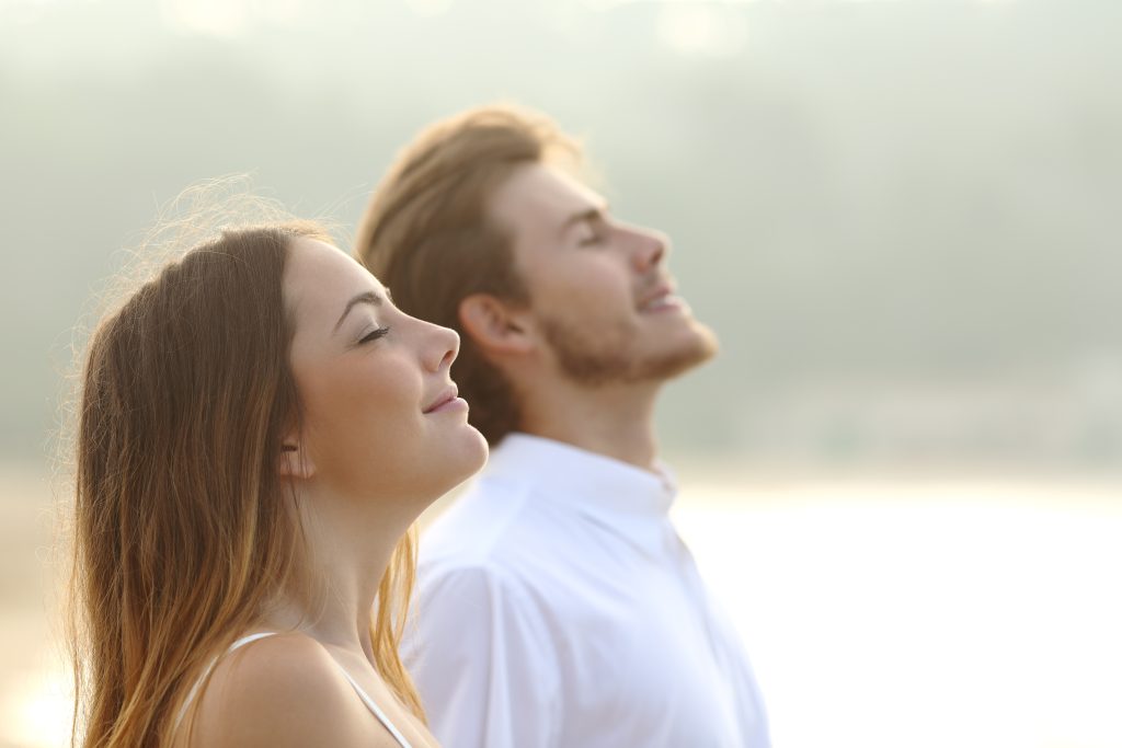 Two smiling people breathe in fresh air